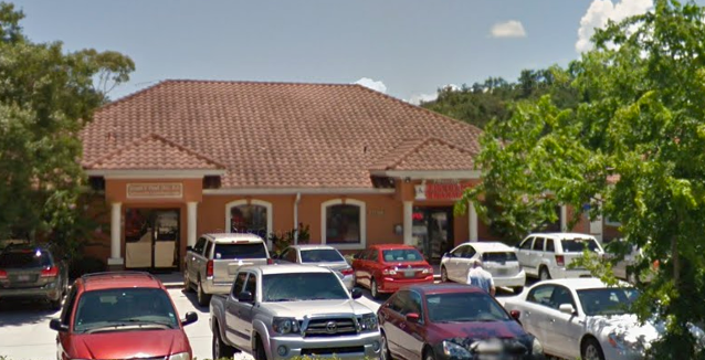 Exterior of a PSJ Discount Pharmacy storefront with cars parked out front