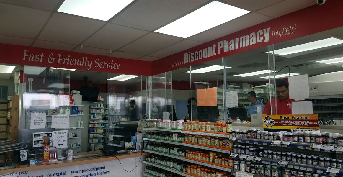 Pharmacy counter at PSJ Discount Pharmacy with the 'Fast & Friendly Service' sign and staff helping customers